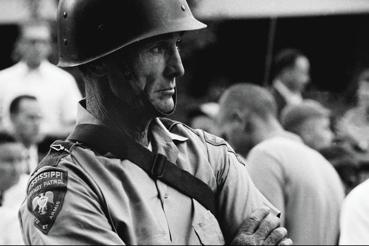 a black and white picture of a police officer wearing a helmet